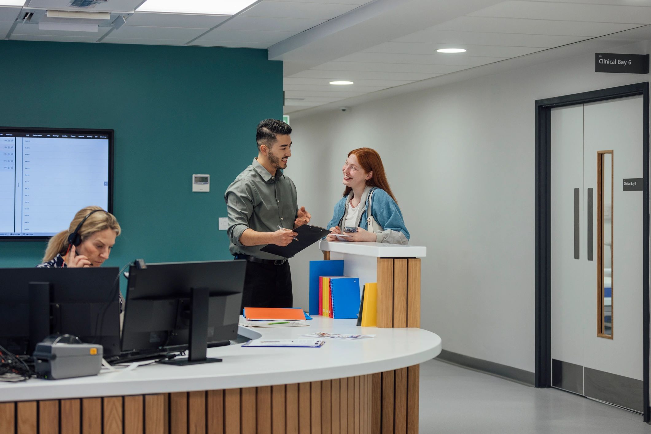 Medical professional helping patient at reception desk
