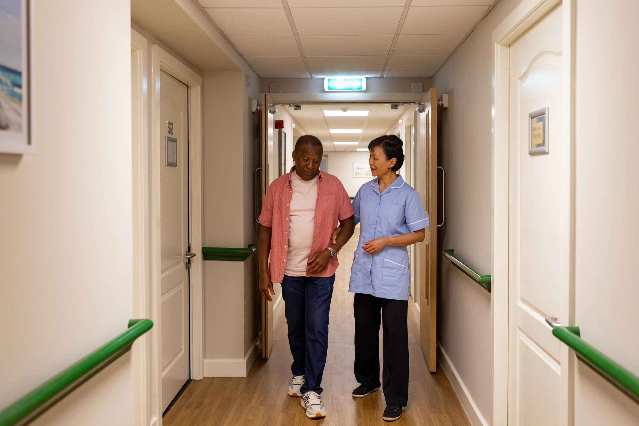 Care worker supporting an older adult in a mobility-focused setting